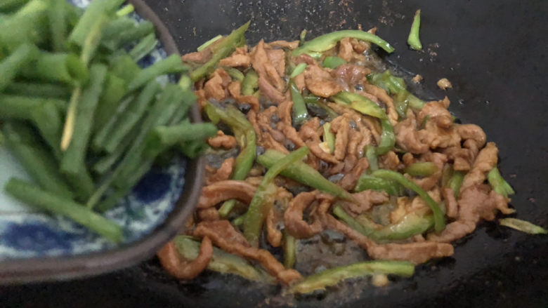 尖椒肉丝,下葱叶翻炒均匀即可(下肉翻炒的时间在2~3分钟左右,炒久变老)