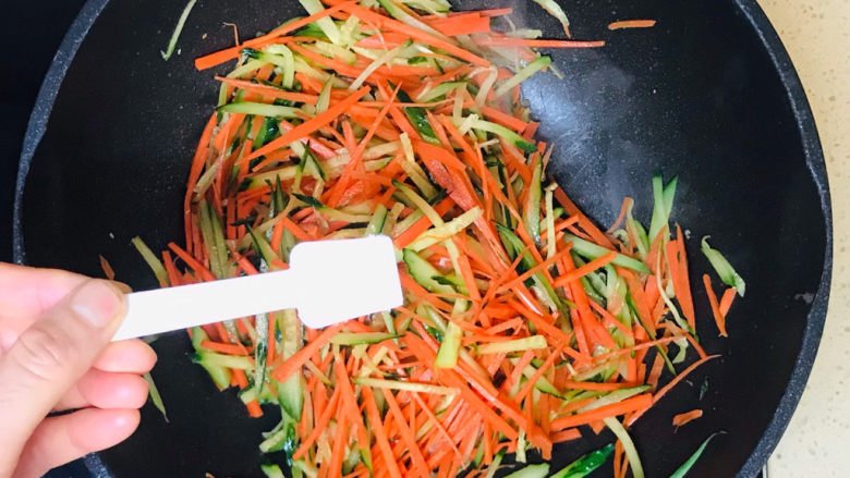 黄瓜炒胡萝卜,一直翻炒至蔬菜断生恹恹后,撒入盐调味