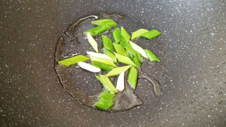 黄瓜炒胡萝卜,炒锅内重新到少许食用油烧热,下入小葱炒香。