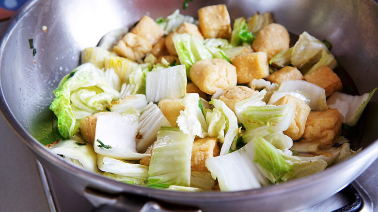 油豆腐炒白菜,<a style='color:red;display:inline-block;' href='/shicai/ 483'>油豆腐</a>入锅一同翻炒片刻,加一汤碗的水,中火慢慢煮开,至白菜软烂。