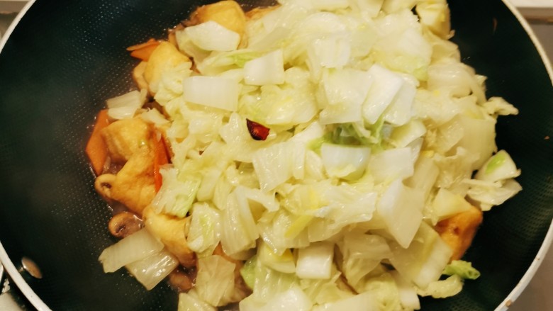 油豆腐炒白菜,放入炒好的白菜,继续翻炒入味。