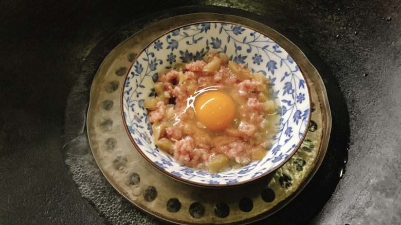 榨菜蒸肉饼,打一个<a style='color:red;display:inline-block;' href='/shicai/ 9'>鸡蛋</a>加入其中,放入烧得沸水得锅中