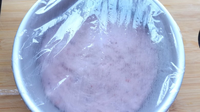 紫薯发糕,取一个模具地下铺一层油纸,旁边刷上油,倒入面糊铺平,盖上保鲜膜醒发至两倍大