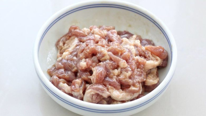 尖椒肉丝,抓拌均匀后淋入一汤匙食用油,拌匀腌制十分钟使之入味。