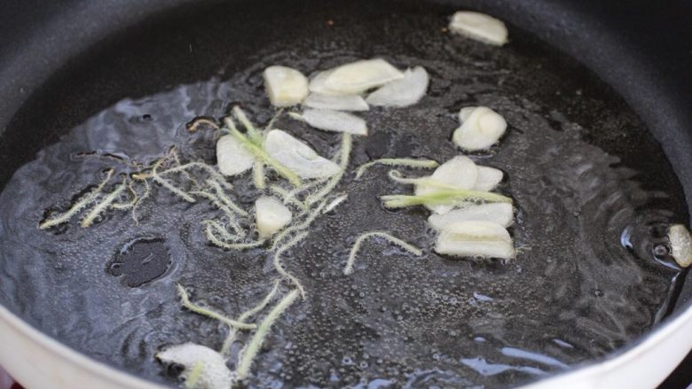 尖椒肉丝,锅中倒适量食用油烧至五成热,放入姜丝和蒜片小火炒香。