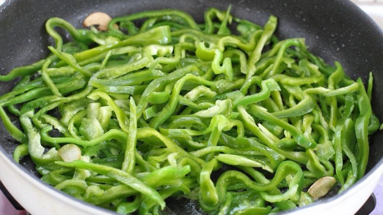 尖椒肉丝,就着锅中底油放入辣椒丝,改大火快速翻炒断生。