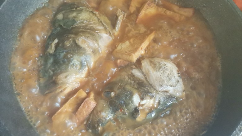 鱼头豆腐煲,由于砂锅太小了,两个鱼头放不下,所以又转到大锅里面中火炖十分钟