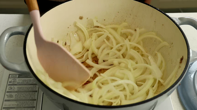 羊肉抓饭,往锅里倒入洋葱丝翻炒2分钟至洋葱变透明