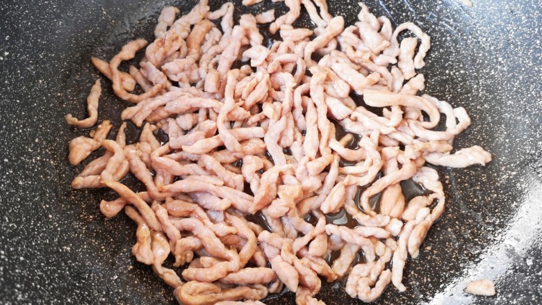尖椒肉丝,炒锅内倒适量的食用油烧热,下入腌好的肉丝大火翻炒至变色,盛出备用。
