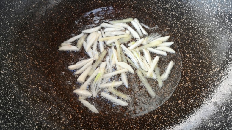 尖椒肉丝,锅里继续倒油烧热,下入姜蒜丝炒香。
