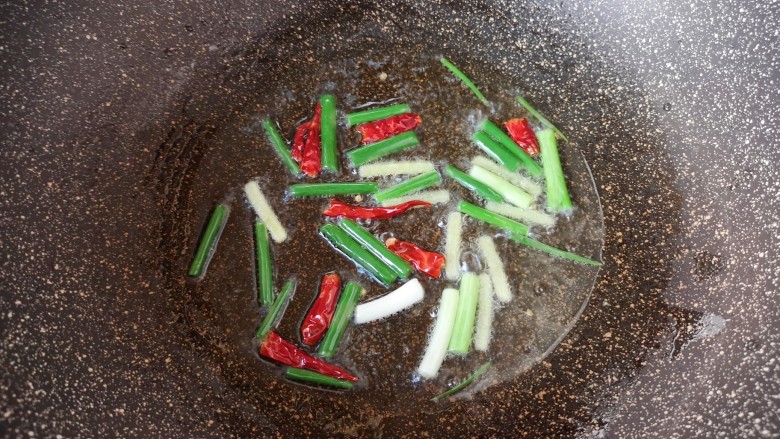 油豆腐炒白菜,炒锅内倒适量的食用油烧热,下入葱姜和干红辣椒炒香。