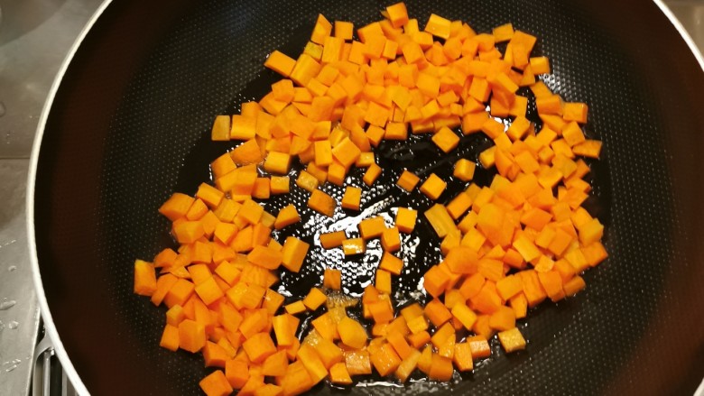 胡萝卜炒玉米,起油锅放入食用油,油热后放入胡萝卜丁翻炒。