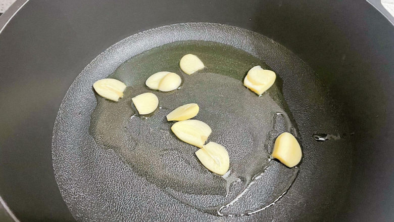 黄瓜炒胡萝卜,锅中倒入适量的食用油烧热,放入蒜片