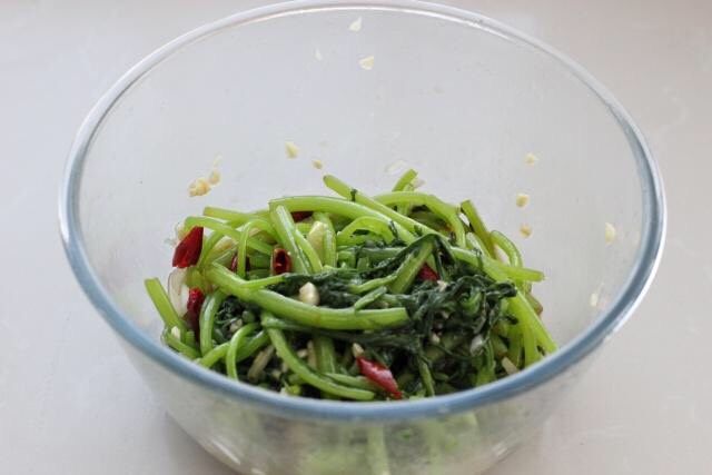 凉拌茼蒿,最后用筷子将所有材料拌匀,装盘食用即可。