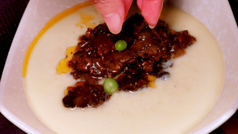 肉末鸡蛋羹,来几个豌豆,盖上盖子,继续蒸2~3分钟即可