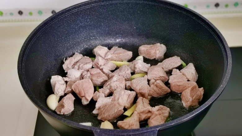 油焖春笋,起油锅,加入葱姜蒜辣炒煸炒出香味,加入梅花肉翻炒。
