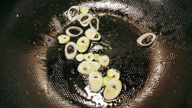 茼蒿鱼丸汤,起油锅放入食用油,油热后放入葱片炒香。