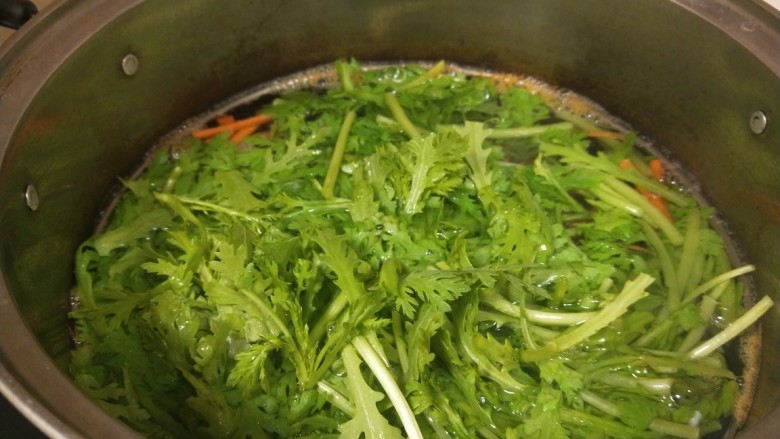 凉拌茼蒿,锅中烧开水倒入茼蒿,一点胡萝卜丝。