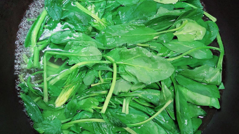 菠菜花生米,锅中倒入水,烧开烫一下菠菜。