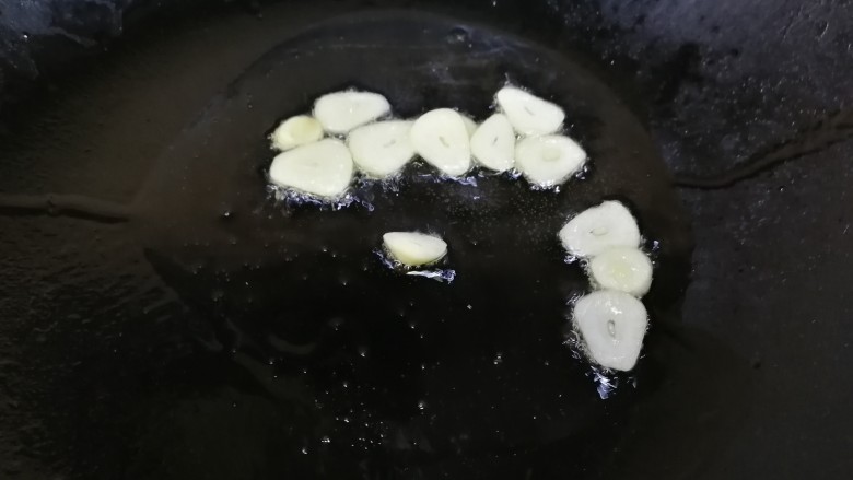上汤菠菜,热锅凉油,放入蒜片,文火炒香。