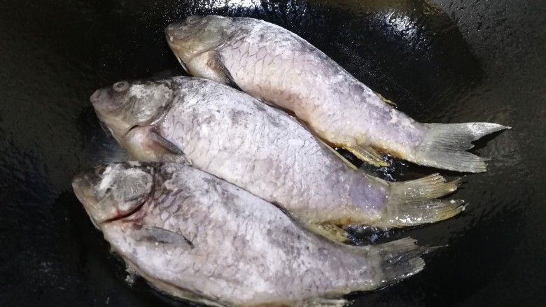 酱焖鲫鱼,热锅倒入适量油,油热放入拍了面粉鲫鱼。