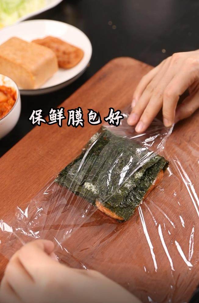 折叠紫菜包饭,将折叠后的紫菜用保鲜膜包好