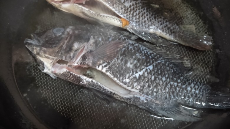 酱焖鲫鱼,平底锅锅中油烧热,放入鱼下去煎