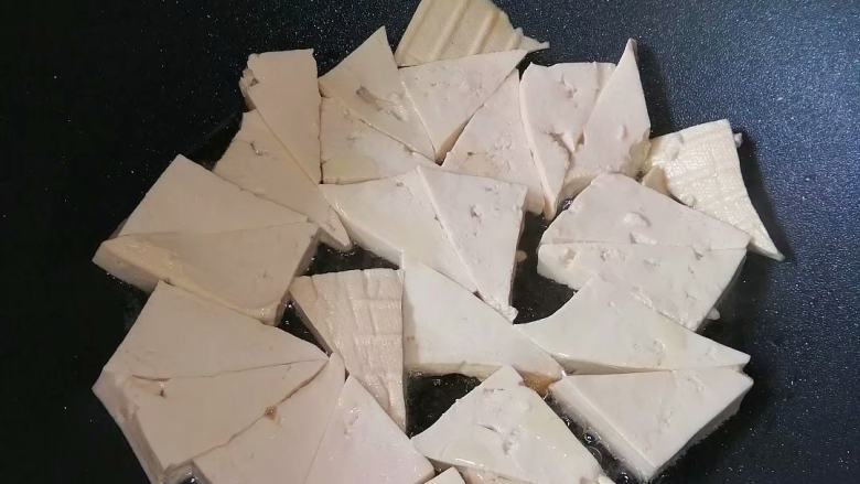 素炒豆腐角,热锅入油,放入豆腐,中火煎