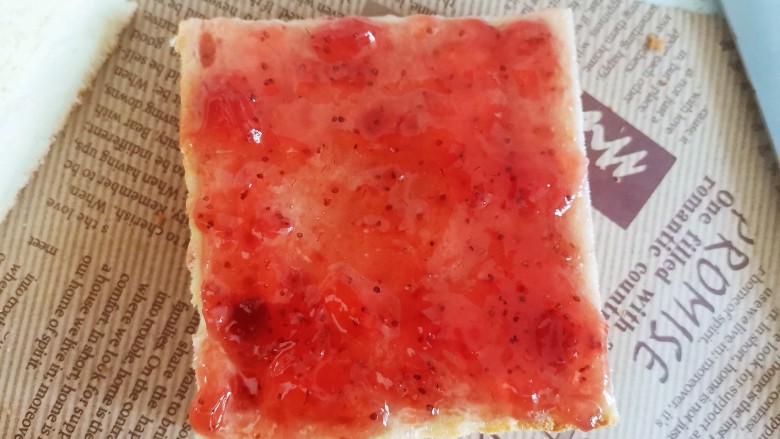 草莓果酱蛋糕,再盖上另一片,上面也抹上草莓酱,从中间切成两半成长方形