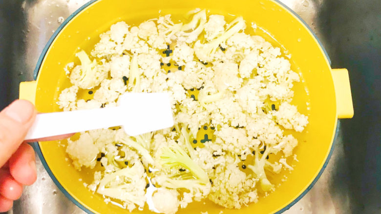 花菜炒鸡蛋,掰成小朵朵,浸泡入清水中,撒入盐,浸泡半小时,去除农药残留