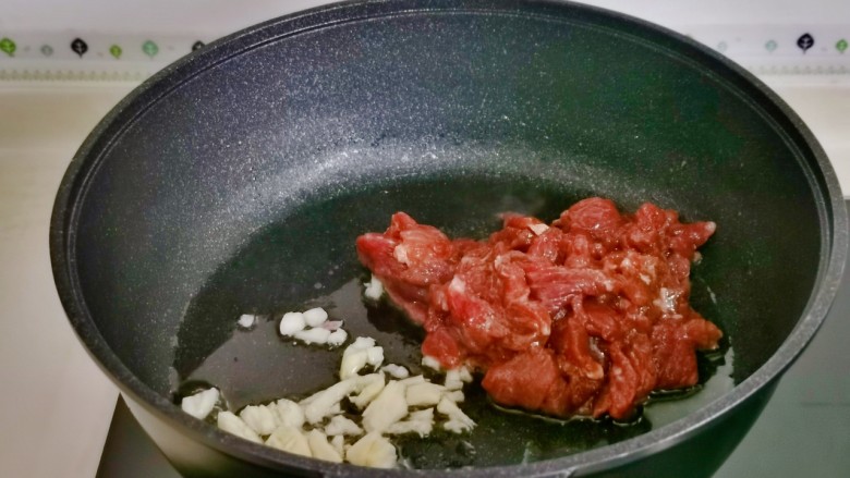 洋葱炒肉片,起油锅,加入蒜末煸炒,再加入腌制好的牛肉。