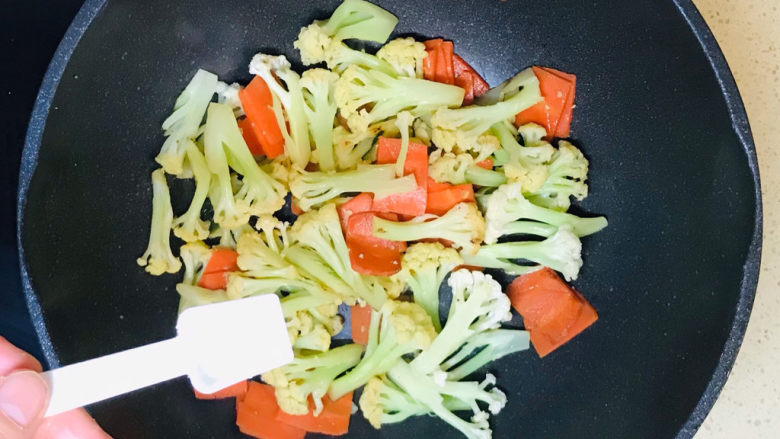 花菜炒鸡蛋,撒上盐调味,翻炒均匀