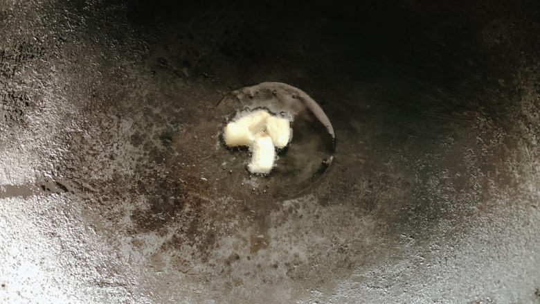 黄瓜炒腊肠,锅烧热油,加入蒜瓣爆炒出香味