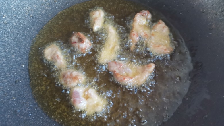 孜然肉片,锅中烧油,油温5成热,下入肉片小火炸至表面金黄捞出控油