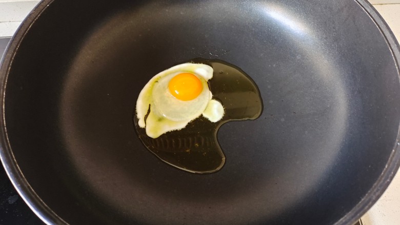 番茄牛肉面,锅中加入适量花生油烧热,打入鸡蛋,煎至两面金黄盛出