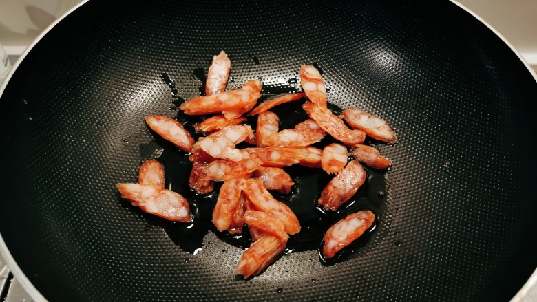 腊肉炒花菜,起油锅放入食用油,放入腊肉肠翻炒。