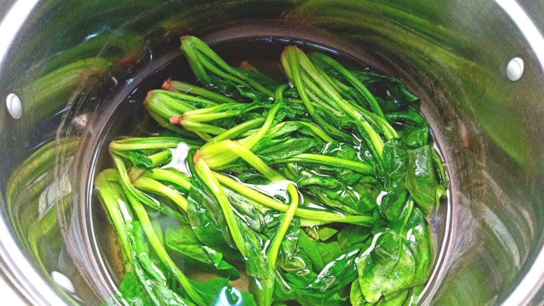 麻酱菠菜,锅中烧水,水开后锅中滴入少许油,下入菠菜烫一分钟