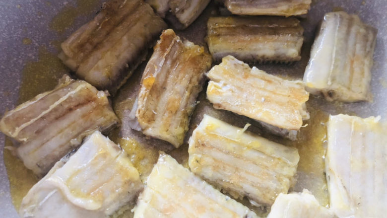 干煎带鱼,热锅冷油放入处理好的带鱼,中小火煎制底部定型上色后翻面。