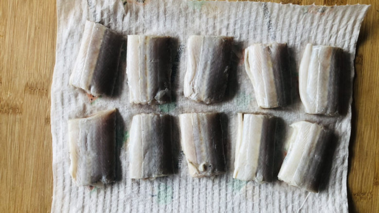 干煎带鱼,取出腌好的带鱼,用厨房纸擦干表面水分,避免煎的时候热油崩到自己。
