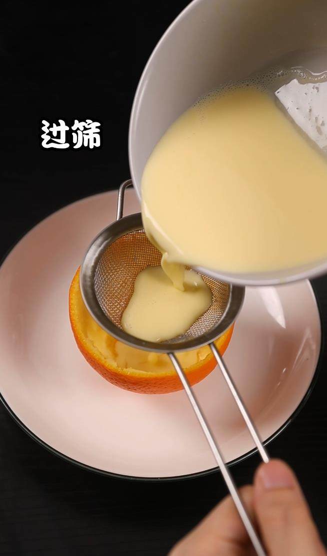 香橙鸡蛋杯,混合好的鸡蛋液过筛倒入挖空的香橙内