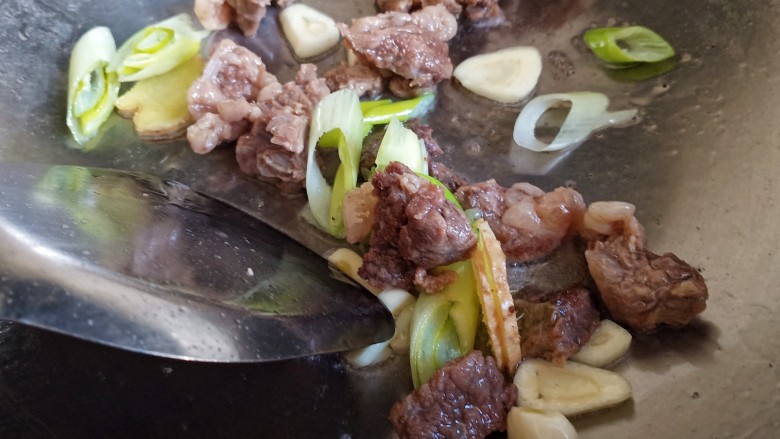 番茄牛肉面,另起锅,倒入少许油,炒香葱姜蒜,放入牛肉粒。
