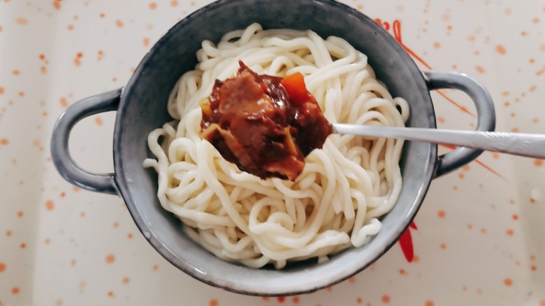 番茄牛肉面,煮熟的面条盛到面碗里,加入适量番茄牛肉料汁。