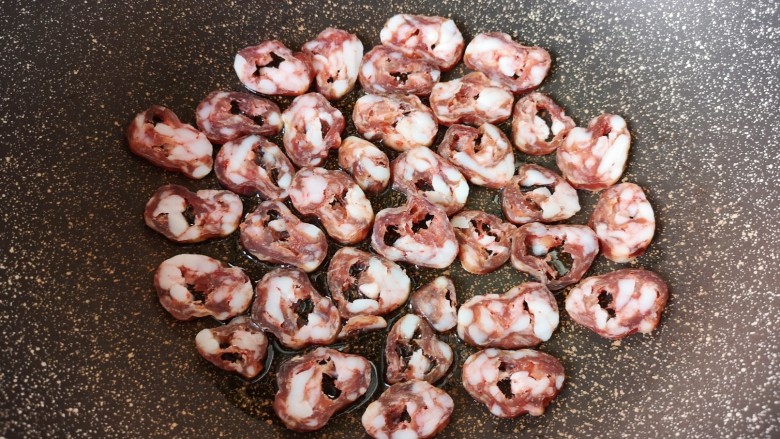 黄瓜炒腊肠,炒锅内倒适量的食用油烧热,码入腊肠片。