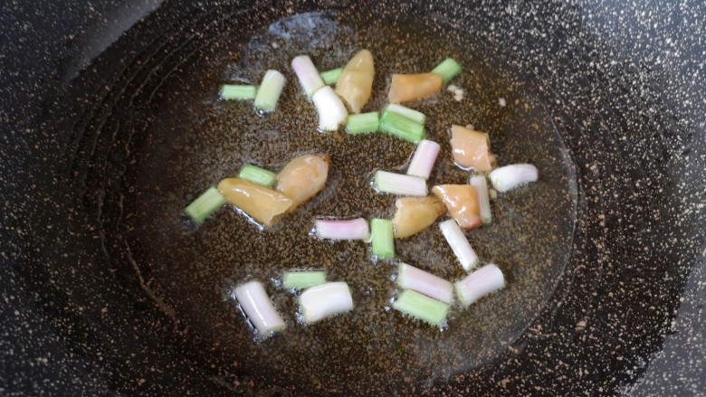 泡椒藕丁,炒锅内倒适量的食用油烧热,下入葱段和泡椒炒出香味。