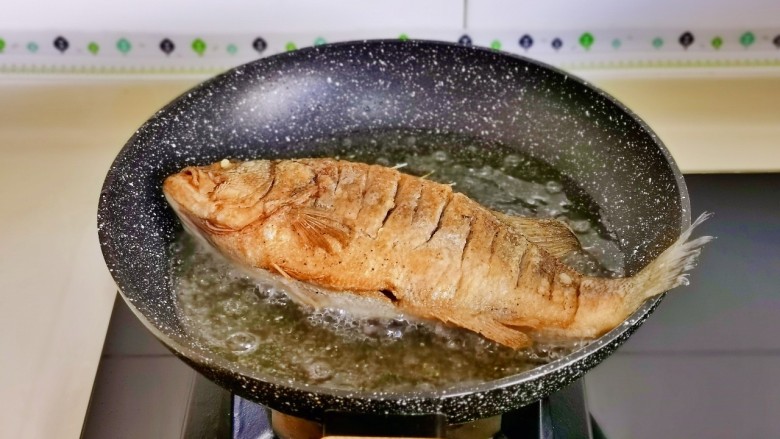 番茄鲈鱼,中小火炸至两面金黄捞出。(鱼尾巴可以剪下来,做好后再摆上,这样比较好看)