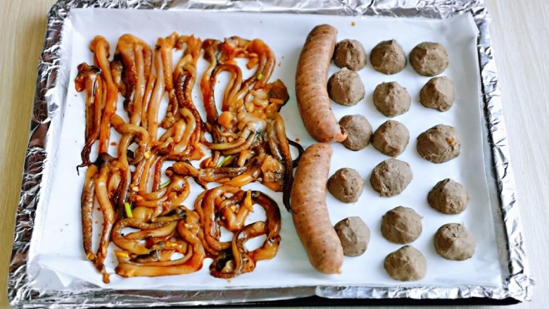 爆炒鱿鱼须,烤盘首先垫上锡纸,再垫上油纸,把食材摆放在烤盘上。