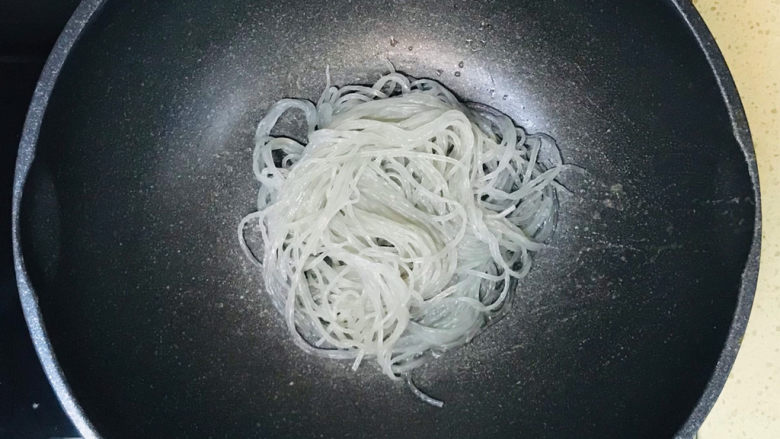 韭菜炒粉丝,将已经泡软的粉丝,控干水分,扔进锅里