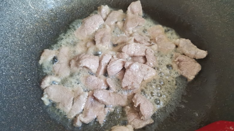杏鲍菇炒肉片,起锅烧油,下入肉片炒至变色