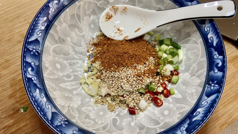 凉拌杏鲍菇➕凉拌酸辣杏鲍菇,取一耐热大碗,加入葱白,蒜蓉,小米辣,一汤匙熟白芝麻,半汤匙辣椒粉,喜欢吃辣的宝贝可以多加点