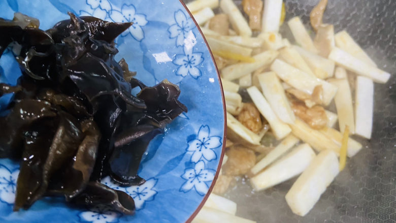 杏鲍菇炒肉片,倒入黑木耳翻炒片刻